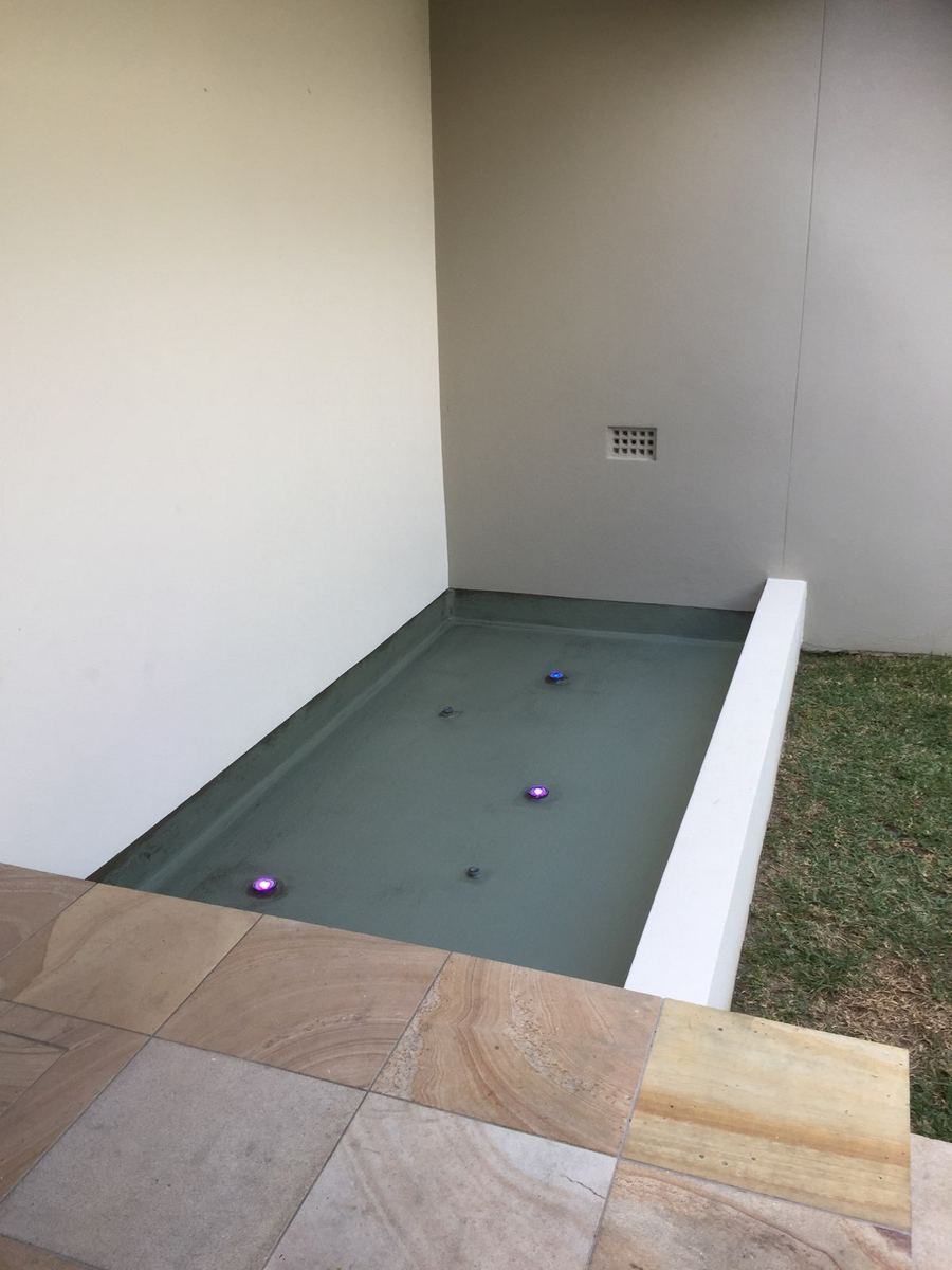 Water feature with sandstone paving and pond